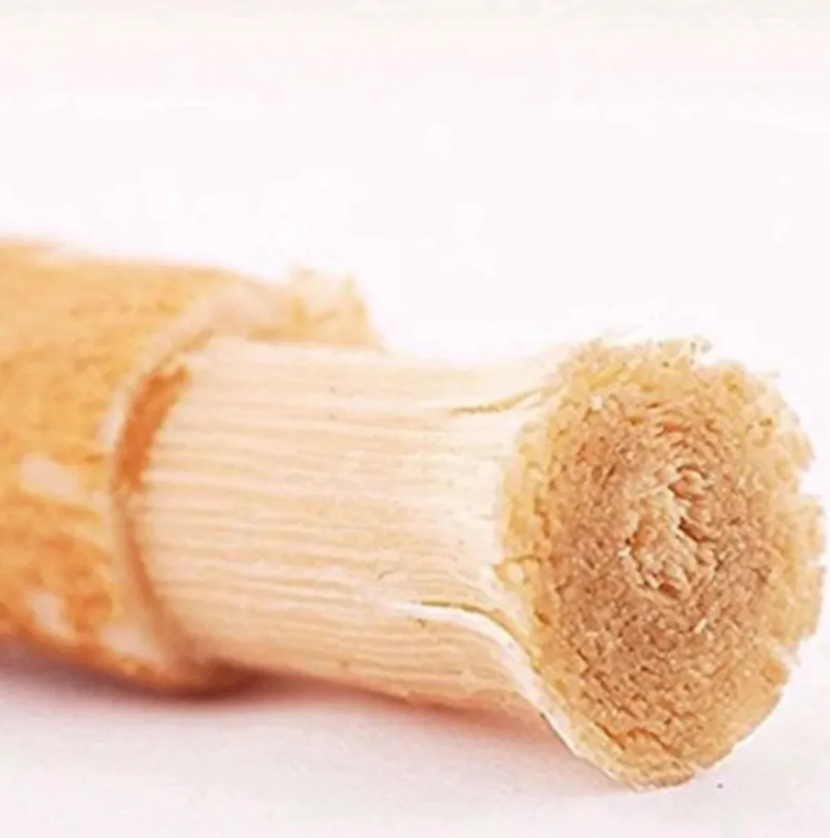 “Natural miswak tooth‑cleaning stick used for traditional oral hygiene, thin 15cm wood branch with frayed brushing tip.”