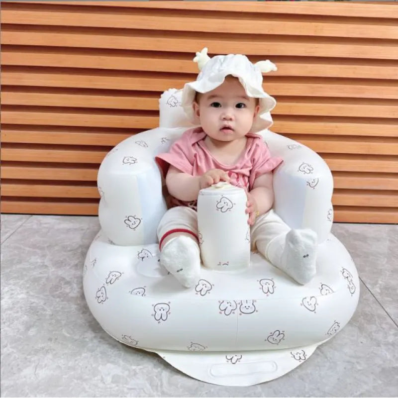 “Inflatable baby chair with supportive backrest and center post, featuring pink bunny pattern, designed for safe seating during dining or bath time.”