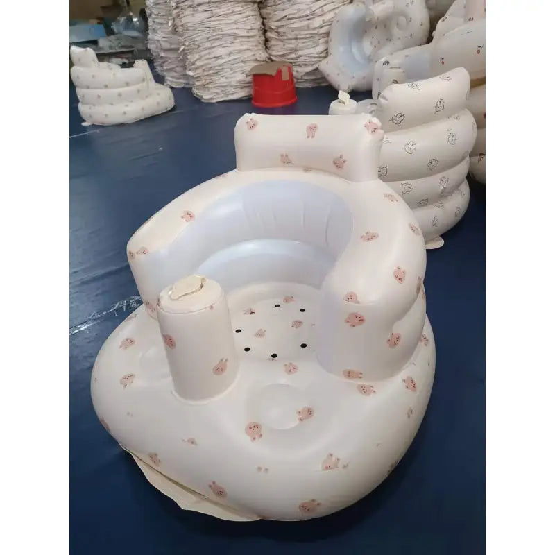 “Inflatable baby chair with supportive backrest and center post, featuring pink bunny pattern, designed for safe seating during dining or bath time.” 