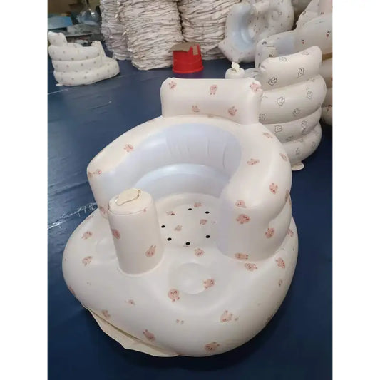 “Inflatable baby chair with supportive backrest and center post, featuring pink bunny pattern, designed for safe seating during dining or bath time.” 