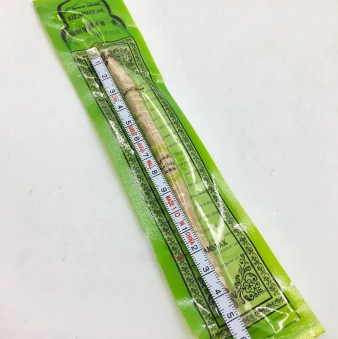 “Natural miswak tooth‑cleaning stick used for traditional oral hygiene, thin 15cm wood branch with frayed brushing tip.”